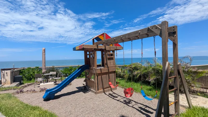 Área infantil de Aldea Ananta, con juegos y el mar de frente.