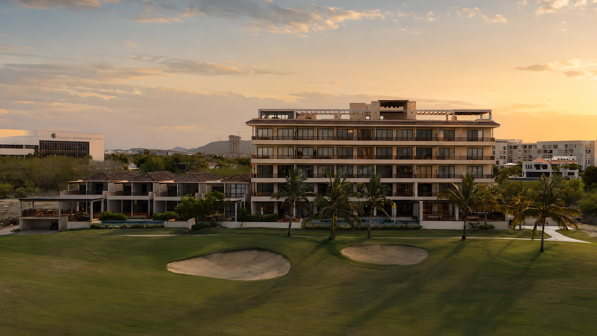 Mangata Golf & Living al atardecer, con los departamentos y villas iluminados frente al campo de golf de Marina Mazatlán