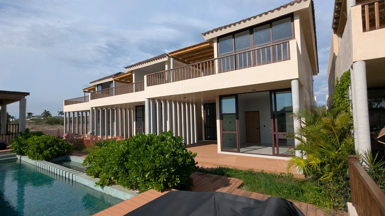 Las villas de Mangata vistas desde el jardín, con sus terrazas altas bajo pérgola de otate