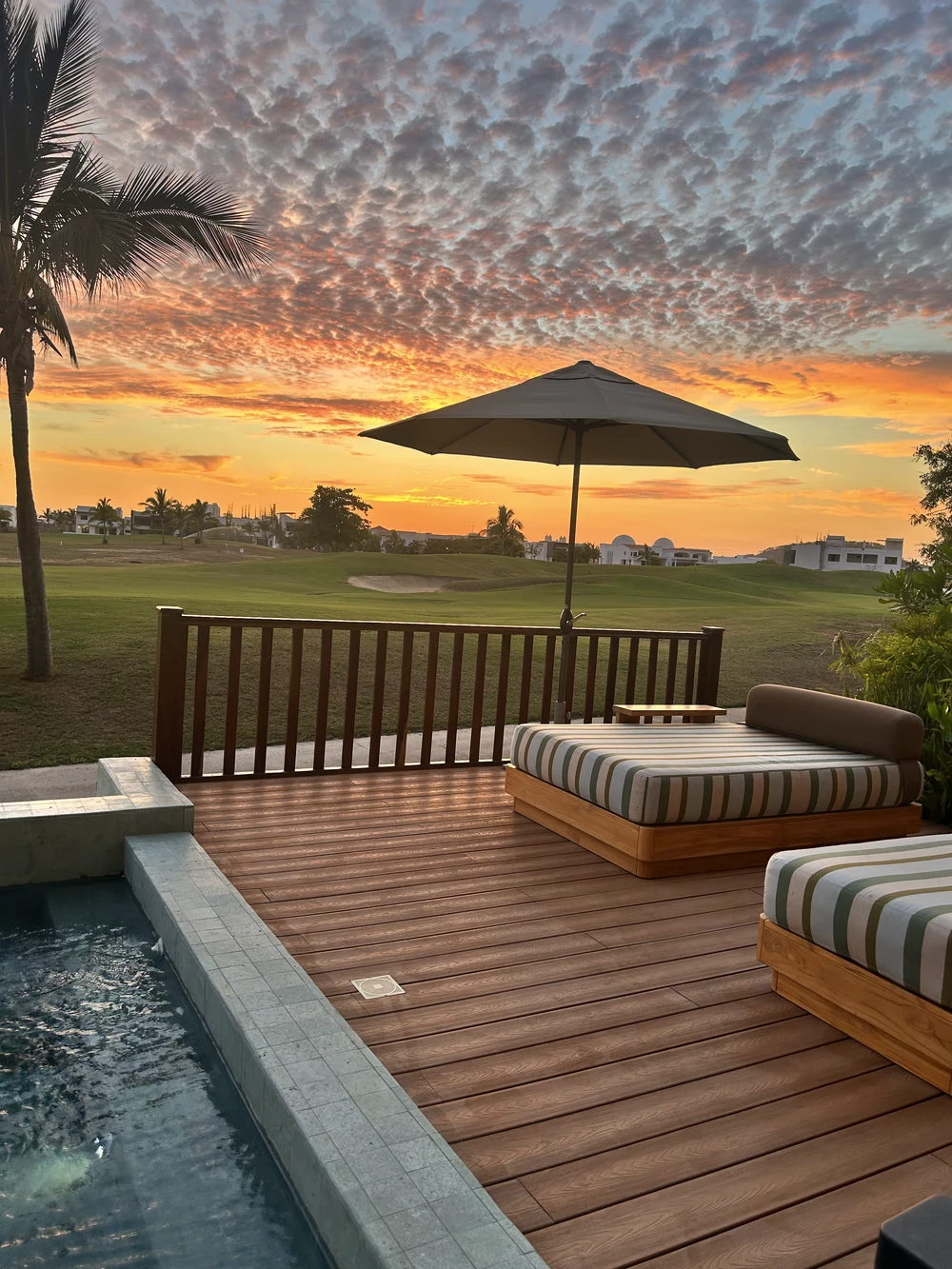 Atardecer dorado sobre el campo de golf de Mangata, desde una terraza privada con alberca en Marina Mazatlán